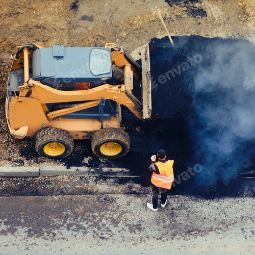 Preview: A Road Worker, A Small Bulldozer And A Large Pile Of Hot Asphalt