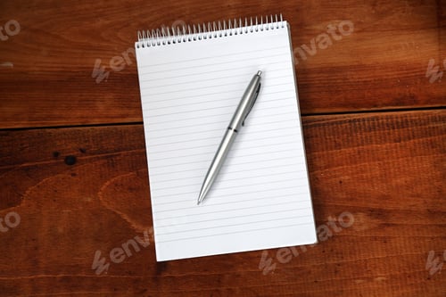 Preview: Black Pencil Lying On The Notepad On A Wooden Table.