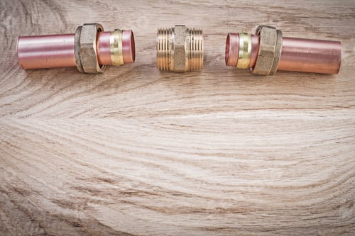 Preview: Copper Water Pipe Threaded Hose Nipples On Wooden Board Plumbing Concept.