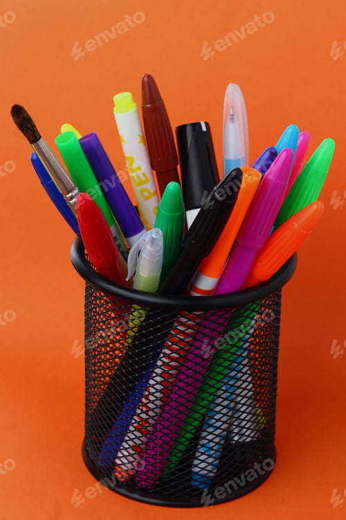 Preview: Stationery Glass With Felt-Tip Pens On An Orange Background, Horizontal