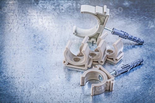 Preview: Heap Of Water Pvc Pipe Clamps On Metallic Surface Construction Concept.