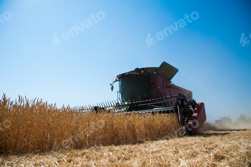 Preview: Agriculture. Combine Harvester On A Wheat Field With Blue Sky