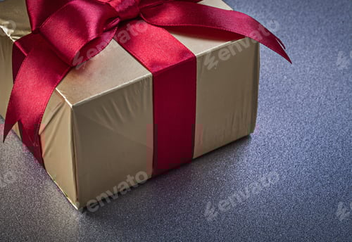 Preview: Gold Gift with Red Ribbon on Grey Surface