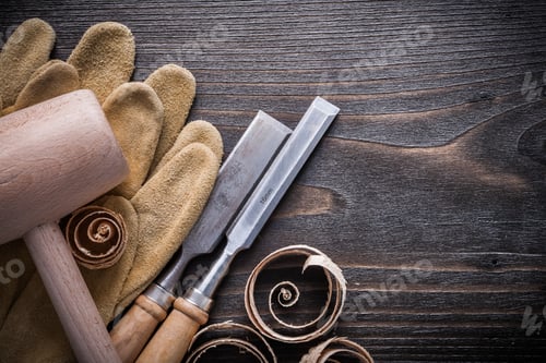 Preview: Brown Leather Gloves Flat Chisels Wooden Hammer And Planning Chips On Vintage Wood Board
