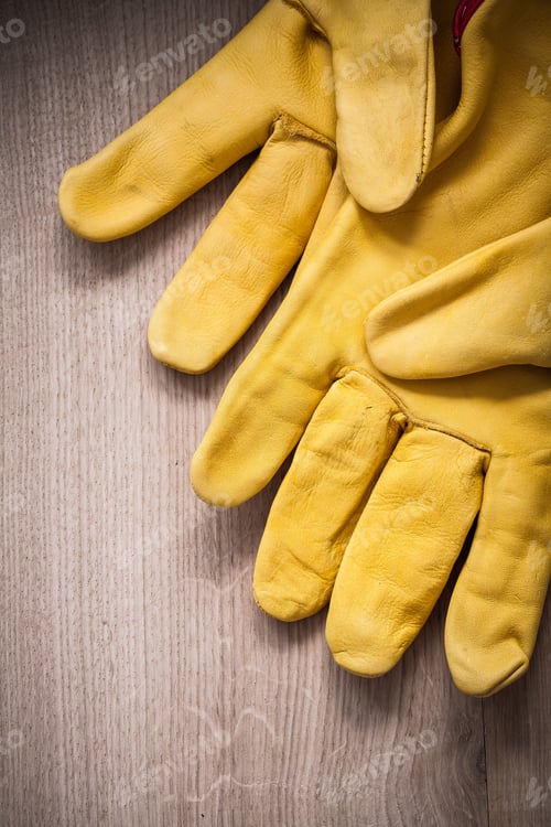 Preview: Pair Of Yellow Leather Protective Gloves On Wooden Background Agriculture Concept.