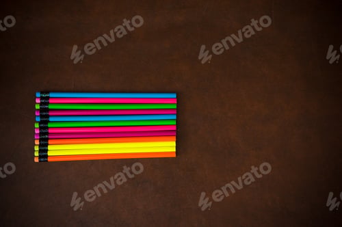 Preview: Wooden Desktop With Colorful Pencil On The Left Side, Red Yellow, Blue, Green And Purple