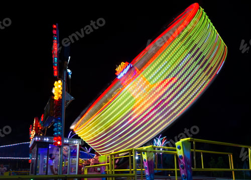 Preview: Centrifuge Wheel Moving At Night. Wheel Fun With Illumination Against Dark Night Sky.