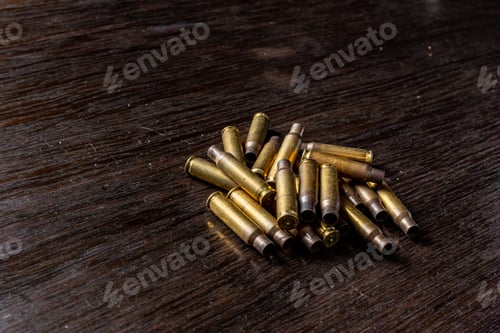 Preview: Empty Bullet Casings On A Dark, Wooden Table.
