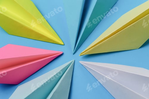 Preview: Multicolored Noses Of Paper Airplanes On A Blue Background