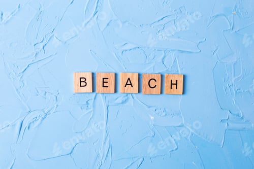 Preview: Word Beach From Wooden Blocks On Blue Textured Background. Top View.