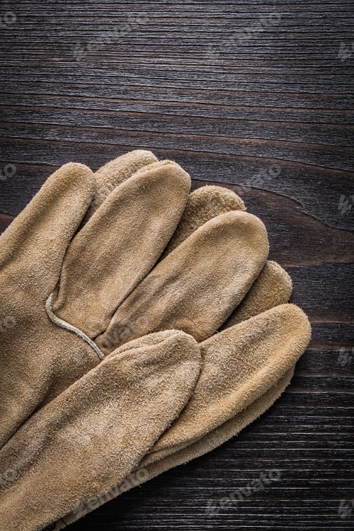 Preview: Leather Working Gloves On Vintage Wooden Board Vertical Version Construction Concept.