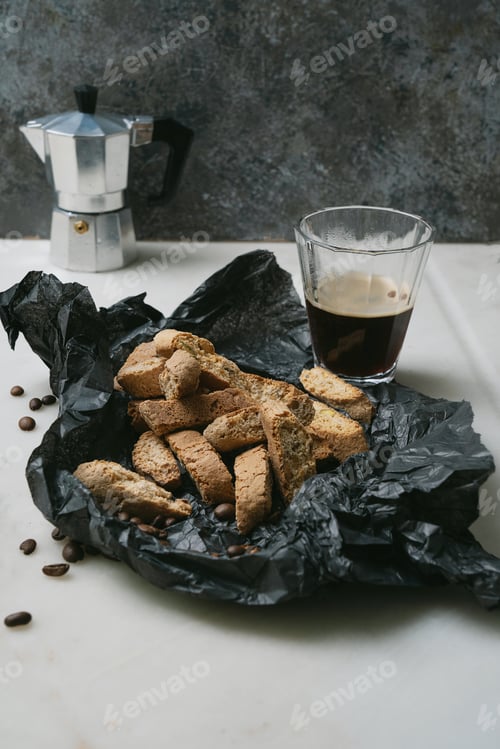 Preview: Cantucci, Typical Italian Dry Almond Biscuits And A Cup Of Morning Coffee With Moka Pot On Black