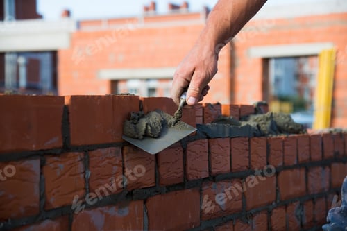 Preview: Bricklayer Worker Installing Brick Masonry On Exterior Wall. Professional Construction Worker