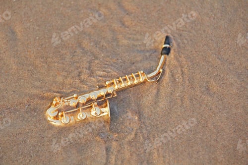 Preview: The Golden Alto Saxophone Lies On The Sand Or On The Beach. Musical Cover And Creative. Design With