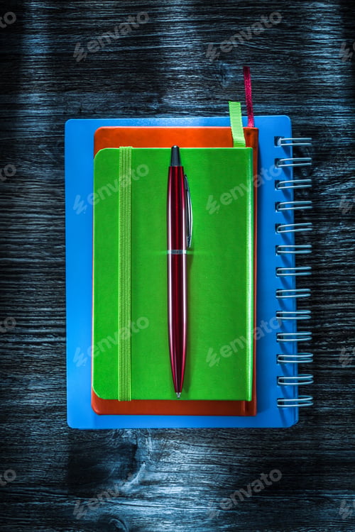 Preview: Pile Of Pocketbooks Pen On Vintage Wooden Board.