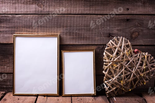 Preview: Two Empty Golden Frames Different Sizes And Decorative Heart With Fairy Light On Aged Wooden