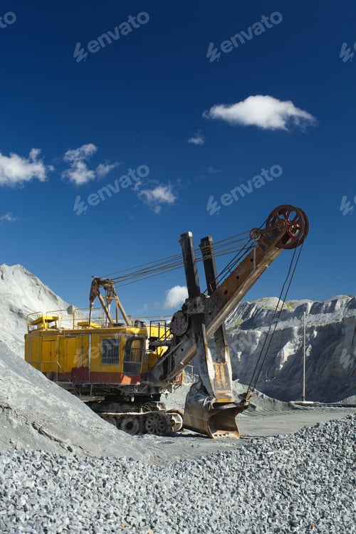 Preview: Powerful Excavator Standing In A Quarry On A Background Of Blue Sky With Clouds.
