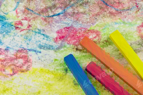 Preview: View Of A Group Of Differently Colored Chalk Lying On Colorful Drawings Of Paper