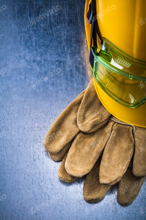 Preview: Construction Leather Gloves Building Helmet And Plastic Protective Eyewear On Scratched Metallic