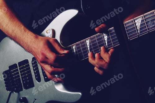 Preview: Young Handsome Creative Man With A Guitar In The Darkness Of A Music Studio, Toned Background