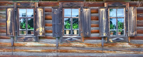 Preview: Old Country Windows. Russia. Windows In The Wall Of Old Logs, With Shiny Glass, Green Flowers