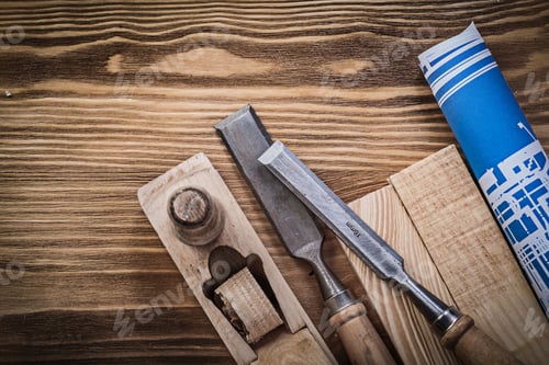 Preview: Blue Rolled Up Engineering Drawing Planer Chisels Wooden Studs On Wood Board.