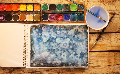 Preview: Watercolor Painting and Palette on Rustic Wood Table