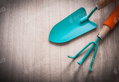 Preview: Gardening Hand Spade With Metal Rake On Wooden Surface Agriculture Concept.