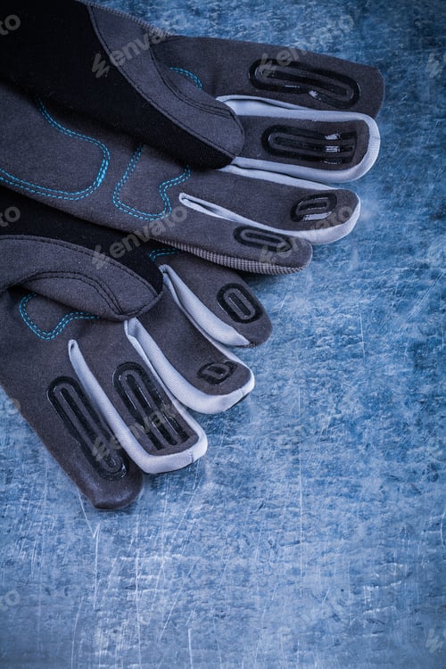 Preview: Staff Protective Gloves On Scratched Metallic Background Top View Image.
