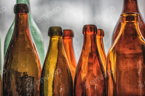 Preview: Brown And Green Old Glass Bottles On Windowsill, With Curtain. Closeup, Daylight.