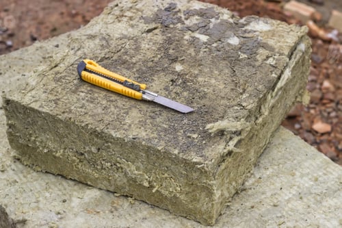 Preview: Mineral Rockwool Panel With A Craft Knive At Construction Site. Selective Focus.
