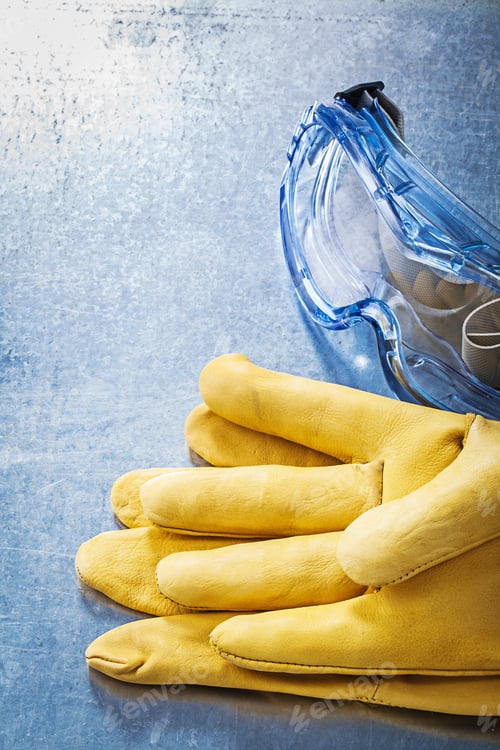 Preview: Plastic Goggles Safety Gloves On Scratched Metallic Background.