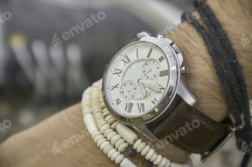 Preview: Wristwatch and beaded bracelets on a person's arm