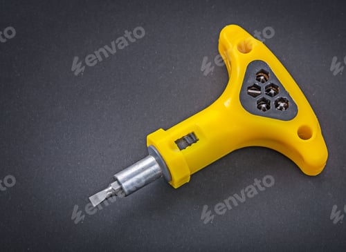 Preview: Yellow Reversible Screwdriver Wih Bits On Black Background.