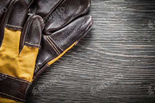 Preview: Brown Leather Safety Gloves On Wooden Board.