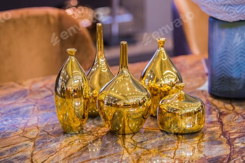 Preview: Four Beautiful Glossy Golden Vases. Gold Fashionable Glass Vases On A Marble Table. Stylish