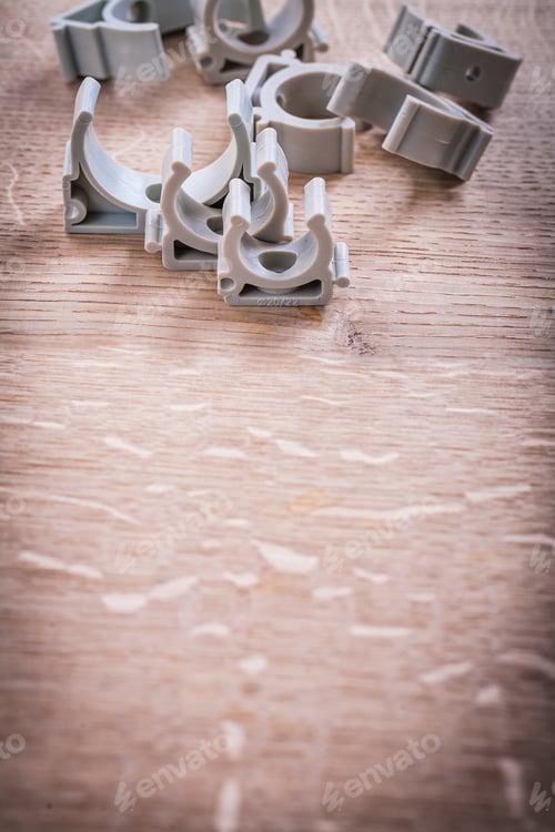 Preview: Organized Copyspace Plastic Pipe Fixators On Wooden Board