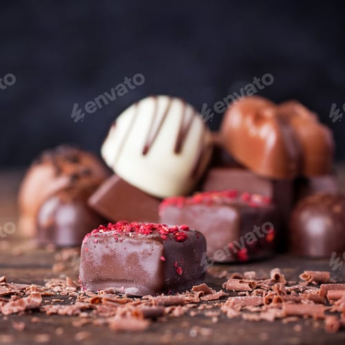 Preview: Traditional Belgian Chocolate Variety Over Rustic Wooden Board, Decorated With Chocolate Swirls