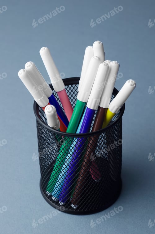 Preview: Colorful Magic Markers In A Pencil Box Holder Over Blue Background