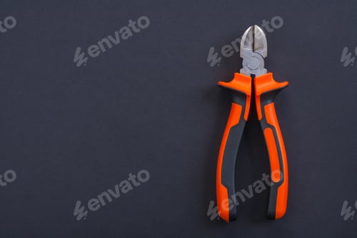 Preview: Opened Nippers With Orange Handles With Copyspace Aerial View On Black Background