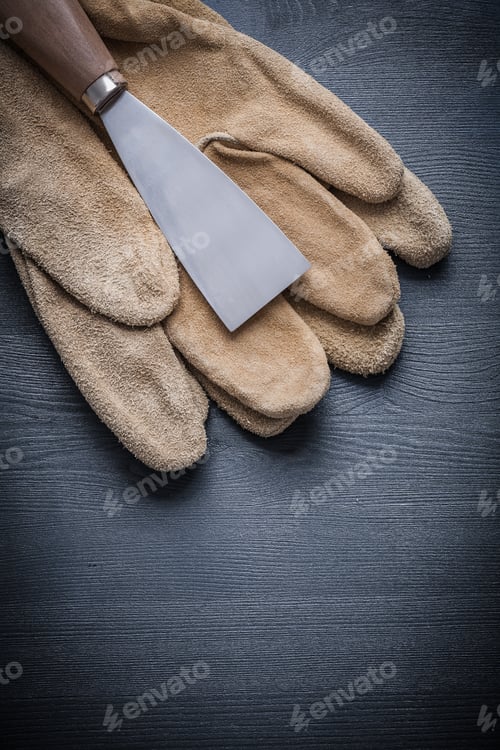 Preview: Steel Paint Scraper On Working Gloves And Wooden Board.