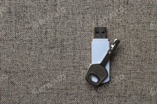 Preview: Key And Flash Drive On The Background Of The Bed