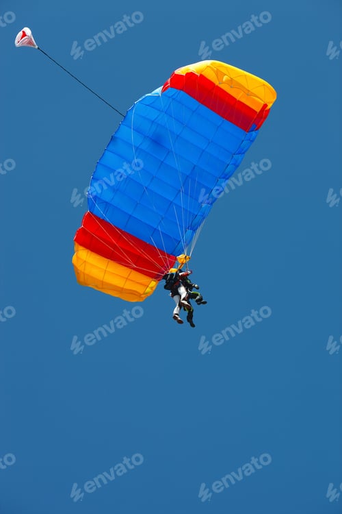 Preview: Tandem-Instructor And Tandem-Passenger Under The Canopy Of The Parachute Against The Blue Sky