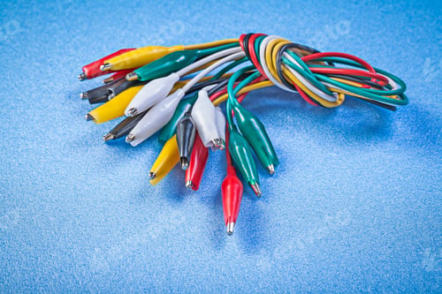 Preview: Assortment Of Multicolored Crocodile Clip Cables On Blue Background.