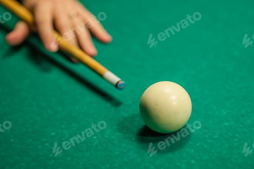 Preview: A Hand Holding A Cue Stick About To Hit A White Cue Ball, Playing Pool.