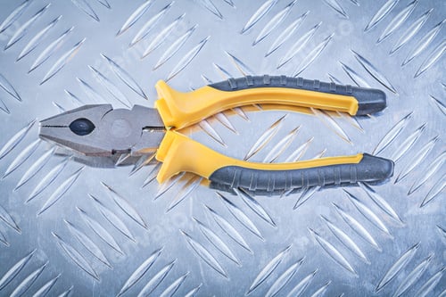 Preview: Gripping Tongs On Fluted Metal Background Construction Concept.