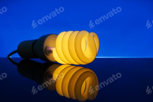 Preview: Glowing Spiral Light Bulb With Reflection On Color Table