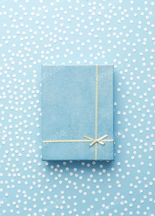 Preview: Christmas Gift Box With Snow Confetti Over Blue Background, Above View