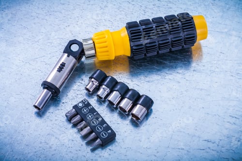 Preview: Reversible Screwdriver Screw Bits And Torxes On Metallic Background Construction Concept.