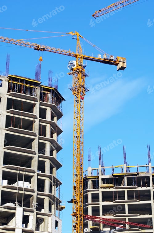 Preview: Building Crane And Building Under Construction Against Evening Blue Sky